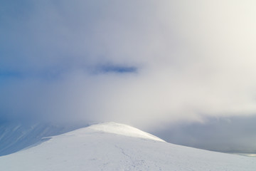 Winter alpine scenery with fresh snow, mist, and beautiful evening light