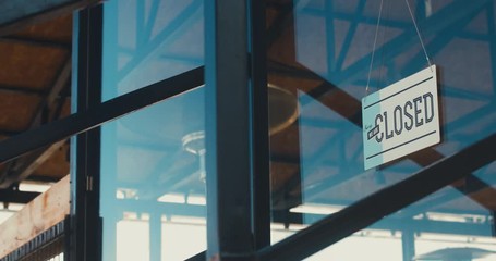 CU closed sign hanging on the entrance door of a small cafe. Out of business. 4K UHD 60 FPS SLOW MOTION