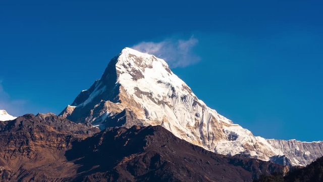 Timelapse nature landscape view of Annapurna South mountain with blue sky in Nepal.