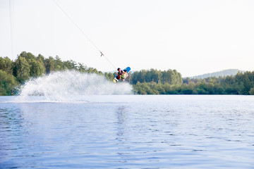 Obraz premium Young man riding wakeboard on a lake