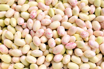 Bunch of peeled white beans. Grains of white beans close-up. The color of beans is white with red inclusions. Macro. 
