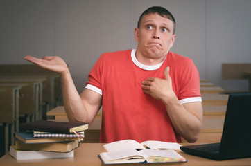 The student is sitting at the table and is looking for excuses for not being ready for the lesson.