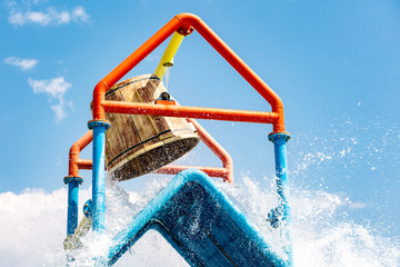 A large bucket of water splashing down at a water park
