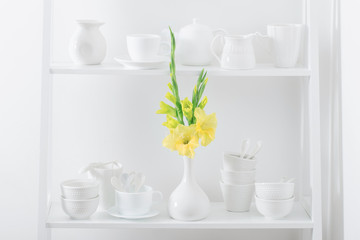 white dishvare with flowers on wooden shelf