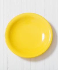 yellow plate on white wooden background