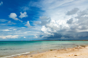 Beautiful white clouds on blue sky over calm sea with sunlight reflection. Tranquil sea harmony of calm water surface. Sunny sky and calm blue ocean.