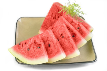 Triangular pieces of red ripe watermelon on a plate. Close up