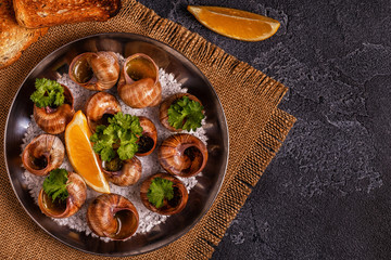 Fried snails with lemon, baguette and parsley.
