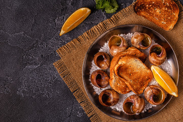 Fried snails with lemon, baguette and parsley.