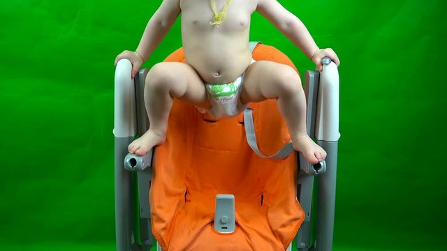 the baby in the diaper crawls on the child seat.