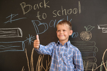 happy European boy at school Board with inscription back to school