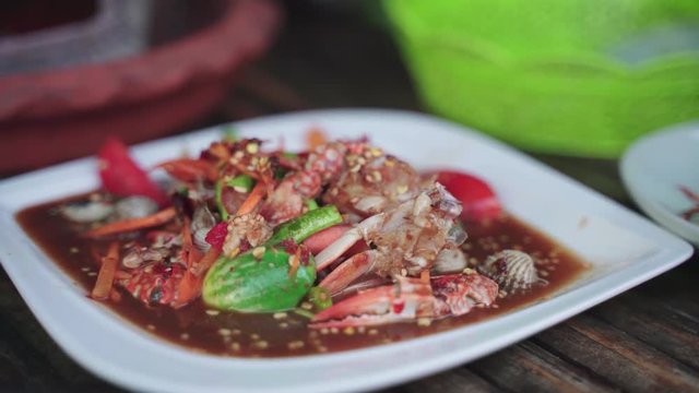Eating Thai sea food Som Tam, spicy papaya salad
