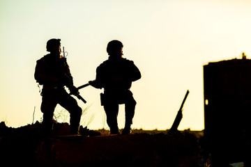 Black silhouettes of pair of soldiers
