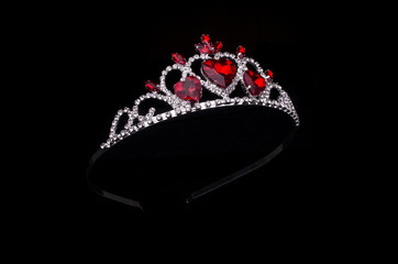 silver diadem with hearts, rubies and diamonds isolated on black