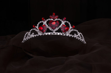 silver diadem with hearts, rubies and diamonds isolated on the fabric - obrazy, fototapety, plakaty