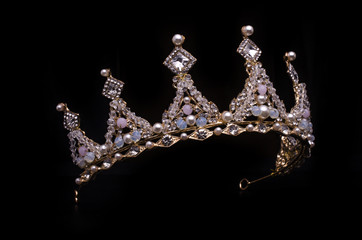 golden crown with pearls and beads isolated on black