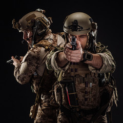 soldiers or private military contractors holding rifle. Image on a black background. war, army, weapon, technology and people concept