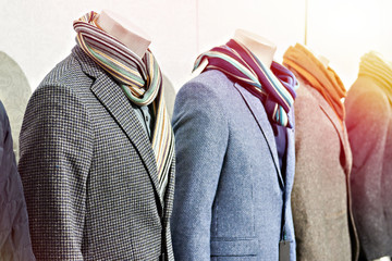 Men's tweed sport coats with scarves in clothing store