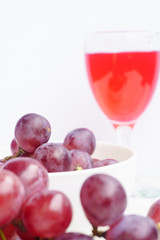 Grape and glass of wine on a white wooden floor