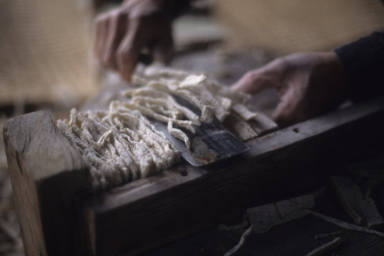 日本の伝統食品の凍みこんにゃくの製造風景、完成した凍みコンニャクのはしを切る