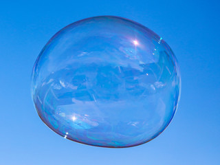 Soap bubbles in flight against the blue sky