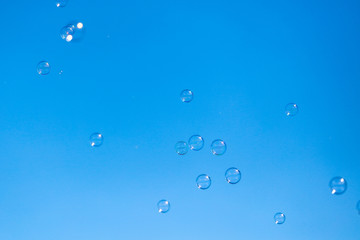 Soap bubbles in flight against the blue sky