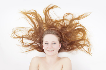 young woman with long reddish blond hair spread out                         