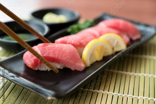 Otoro Tuna Sushi On Black Plate Along With Japanese Sauce
