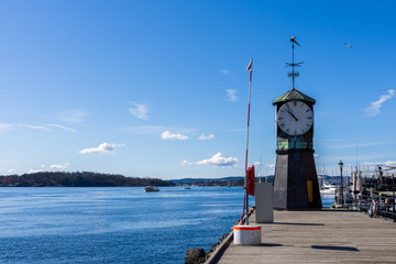 Fototapeta na wymiar Clock located at the Aker Brygge pier on a beautiful, sunny spring day