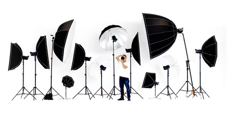 Asian photographers sit on the director's chair with flash studio lights a lot of patterns around on white background.