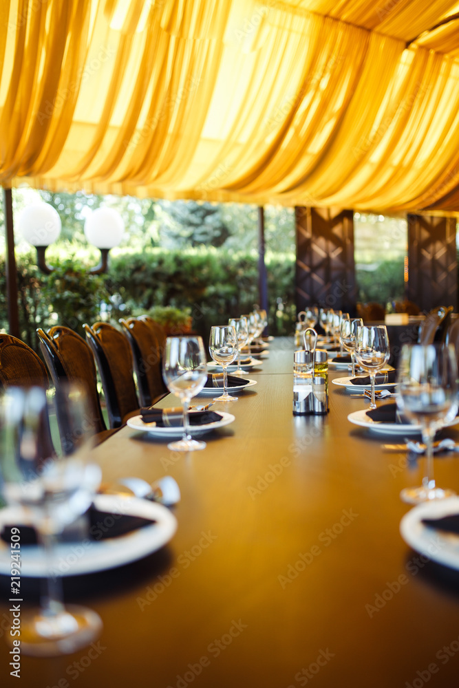 Wall mural Sparkling glassware stands on long table prepared for wedding dinner