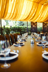 Sparkling glassware stands on long table prepared for wedding dinner