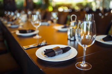 Sparkling glassware stands on long table prepared for wedding dinner.