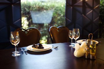 Sparkling glassware stands on long table prepared for wedding dinner.