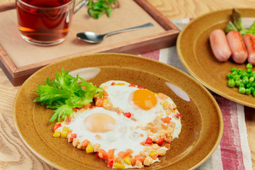 Fried eggs with vegetables and green close up top view