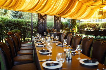 Sparkling glassware stands on long table prepared for wedding dinner
