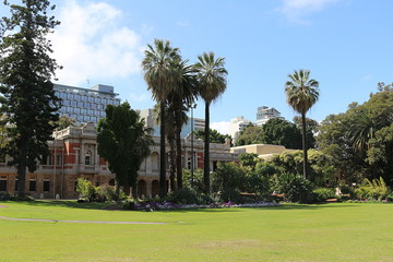 Fototapeta na wymiar Supreme Court Gardens with building of the Supreme Court of Western Australia in Perth