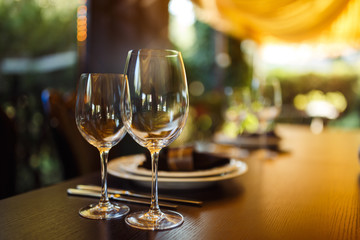Sparkling glassware stands on long table prepared for wedding dinner