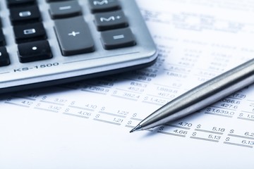 Caclulator and Pen on the Document - Close Up