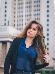 Brunette girl with long hair in dark clothes, in a skirt near the University building-MSU, the student passed the exams