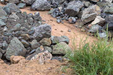 Fototapeta na wymiar Pile of large granite stones near the grass.