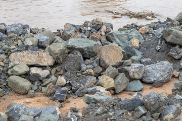 Granite pile on the ground near the river bank.