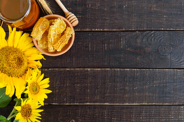 Honey in a glass jar, honeycombs. Products of beekeeping on a wooden table, top view. The concept of healthy eating. Honey theme.