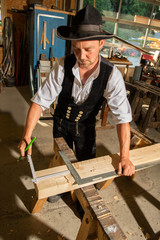anreißen und messen am Holzbalken, Zimmermann bei der Arbeit mit Winkel  und Meterstab