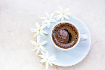 Traditional invigorating Turkish coffee. A white cup of coffee is decorated with flowers. Beautiful feed