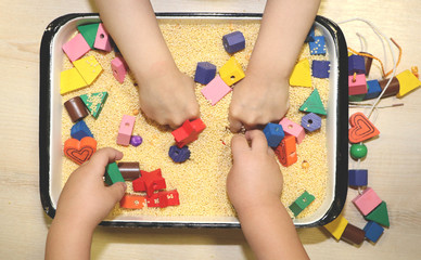 Children playing with kinetic sand, croup and designer in preschool. The development of fine motor...