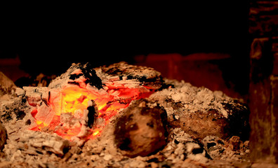 burning coals in the fireplace on a blurred background, the texture of the flame