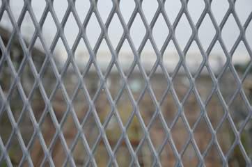 Fototapeta premium Gray metal grid mesh in front of blur view.