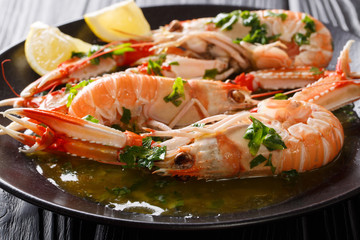 Boiled Nephrops norvegicus, Norway lobster, Dublin Bay prawn, langoustine or scampi close-up with sauce and lemon. horizontal © FomaA