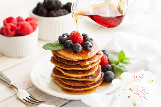 Paleo apple-cinnamon pancakes with berries, maple syrup